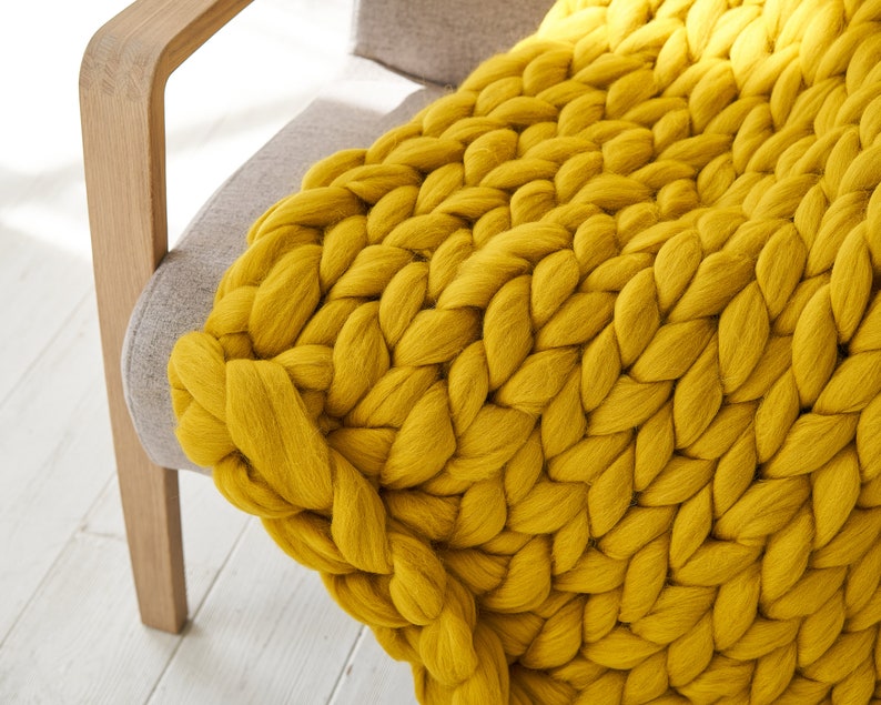 Mustard colour chunky merino blanket throw on an armchair