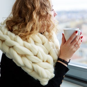 white chunky knit scarf on a girl at the window