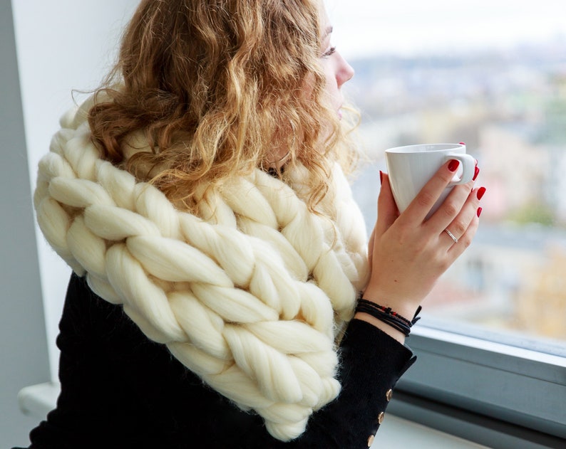 white chunky knit scarf on a girl at the window