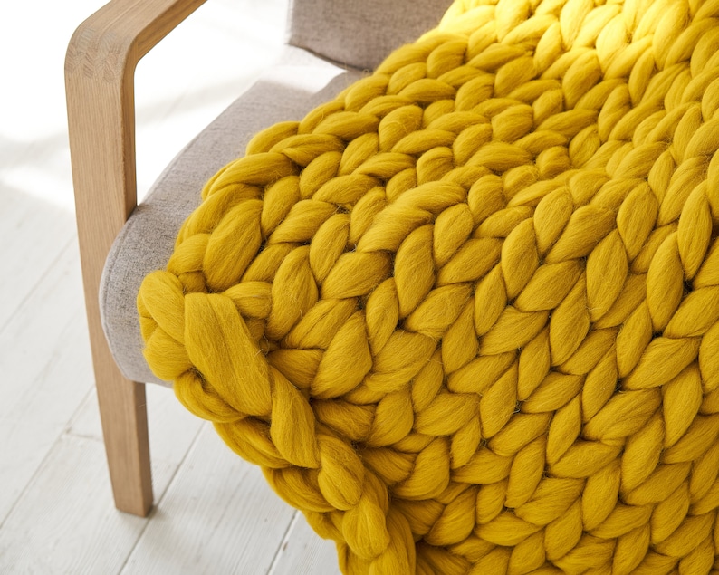 a close up Extreme giant knit blanket throw in mustard