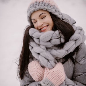 Lady feeling cozy outdoors in winter with chunky knit scarf and hat with gloves