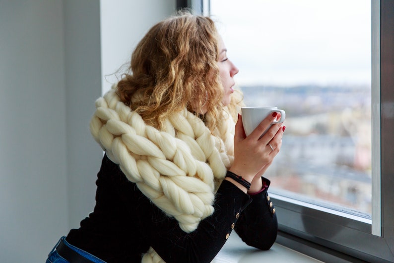 Girl at the window in white fluffy chunky scarf in white