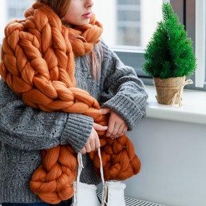 terracotta chunky merino wool scarf o a girl at the window