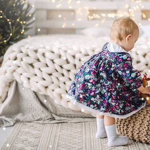 a little girl playing in bedroom with the bed and Chunky knit blanket throw in white