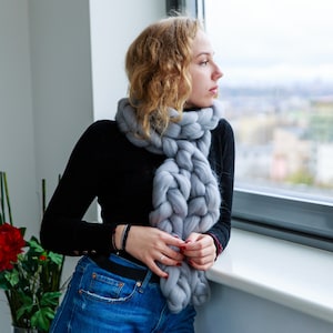 Girl at the window wearing chunky knit scarf in grey