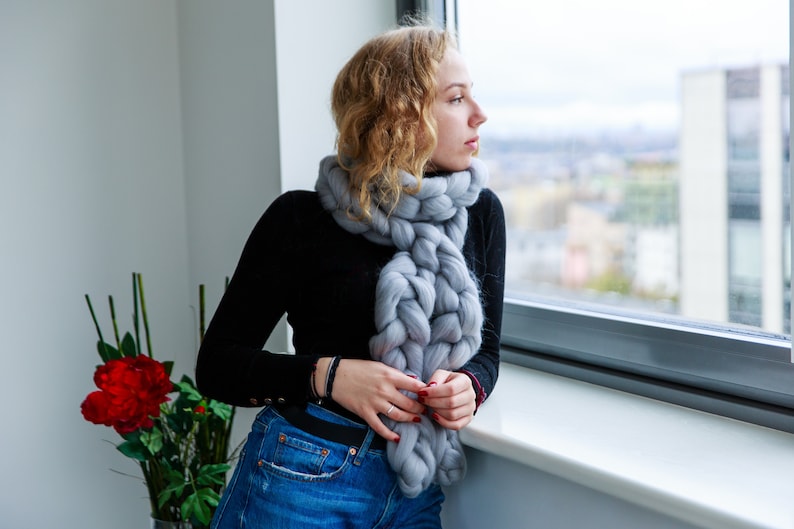 Girl at the window wearing chunky knit scarf in grey