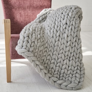 Grey chunky knit throw on an armchair