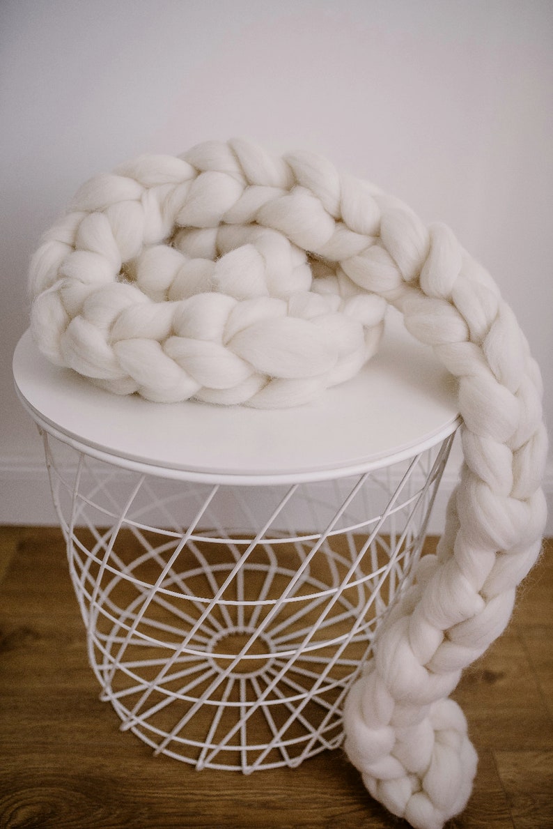 White chunky scarf made of merino wool on the table
