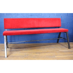 以下が含まれることがあります： 金属製のフレームに赤い布張りのベンチ。シンプルなデザインで、背もたれはまっすぐ、座面は平らです。