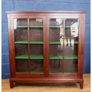 An Edwardian Mahogany Two Door Glazed Bookcase Raised on Tapering Supports