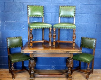 Una mesa de comedor antigua de roble macizo tallado con extensión de cajones y un juego de cuatro sillas de comedor tapizadas en cuero.