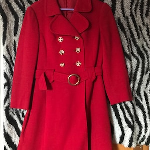 May include: A red double-breasted coat with a belt and gold buttons.