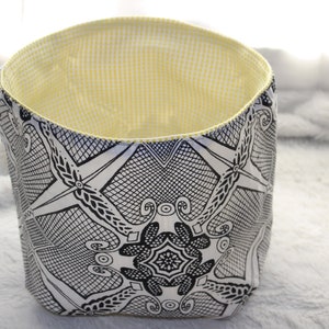 Peut inclure: Un panier de rangement en tissu à motif noir et blanc avec une doublure en vichy jaune.