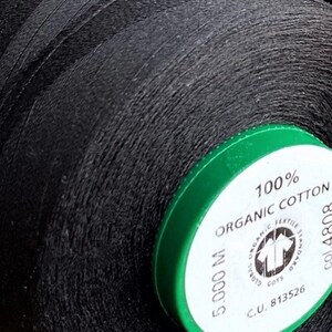 May include: A spool of black thread with a green label that reads "100% Organic Cotton 5,000 M C.U. 813526 col. 4808"