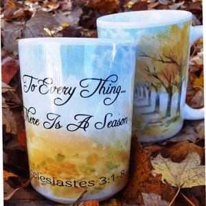 May include: Two white ceramic mugs with watercolor designs. The mug on the left has the text "To Every Thing... There Is A Season" and "Ecclesiastes 3:1-8". The mug on the right has a watercolor design of trees in a forest setting.