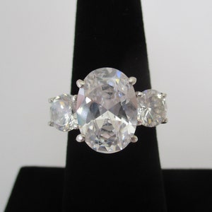 A sterling silver stamped 925 large cubic zirconia trilogy ring 5 - 6 carat centre stone 6.58 grams approx. size UK Q or USA 8