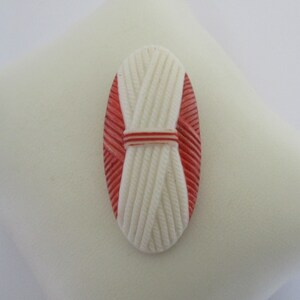 An Art Deco vintage pressed or moulded glass red and white fur collar or dress clip brooch