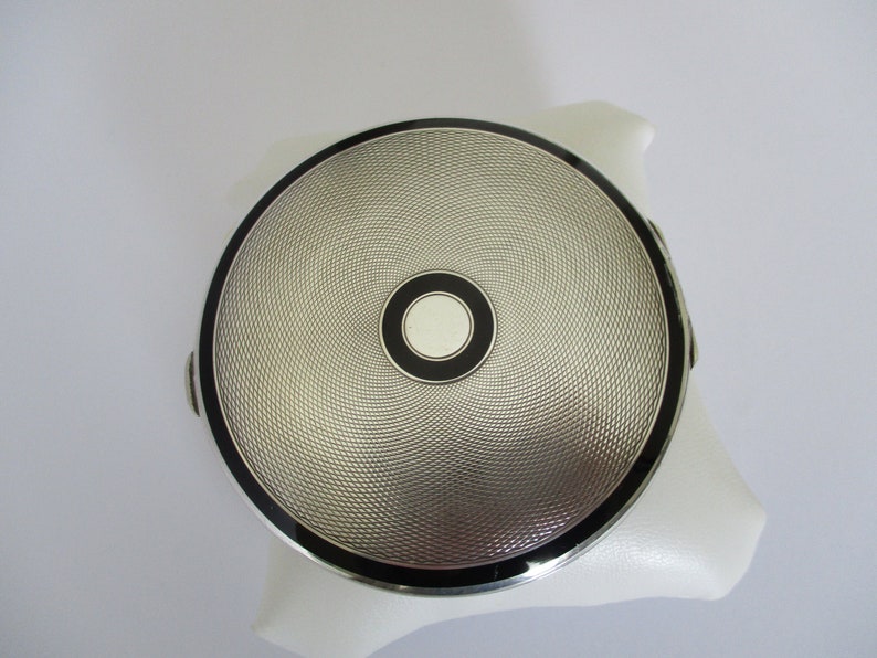 A sterling silver Art Deco hallmarked London 1935 C&C Cohen and Charles shops powder compact with black enamel decoration 74.7 grams
