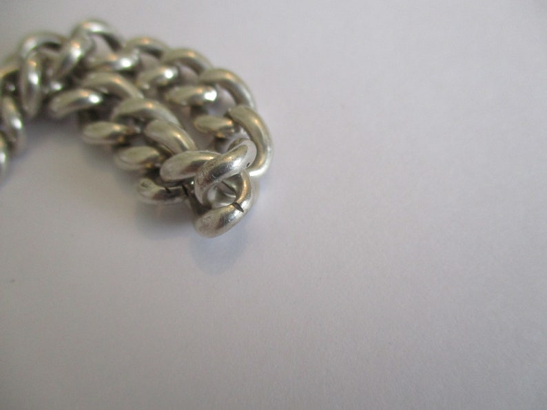 A vintage sterling silver curb link bracelet with a fully hallmarked for 1965 padlock heart clasp