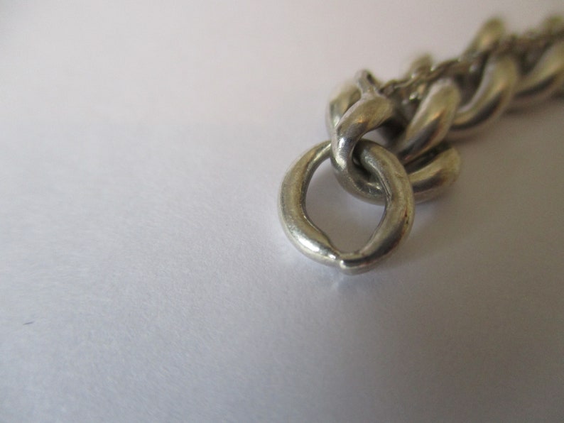 A vintage sterling silver curb link bracelet with a fully hallmarked for 1965 padlock heart clasp
