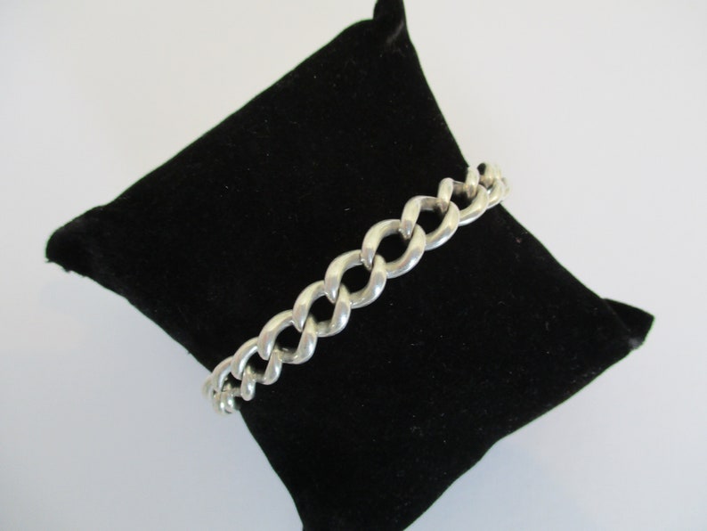 A vintage sterling silver curb link bracelet with a fully hallmarked for 1965 padlock heart clasp