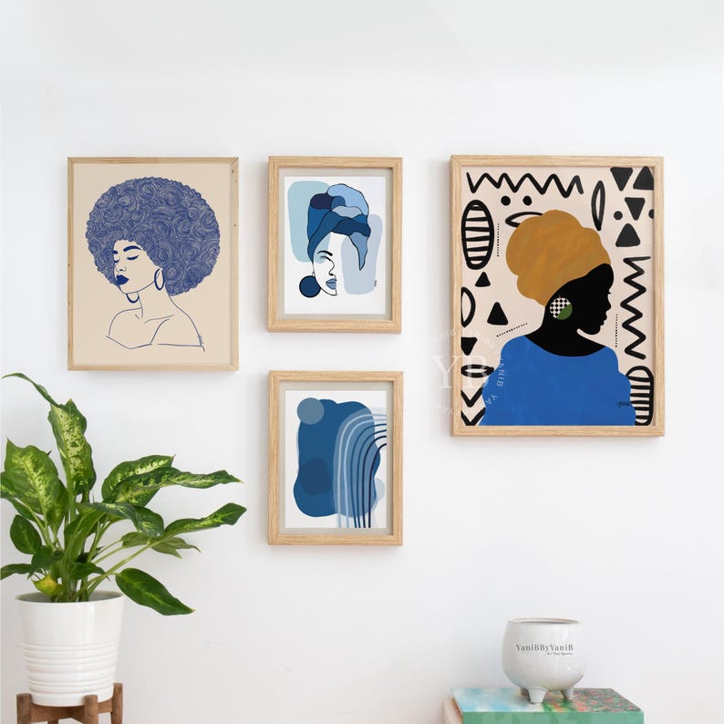 a white wall with four framed artworks displayed on it. The artworks include a portrait of a woman with a blue headscarf, abstract art in shades of blue and white, and a portrait of a woman with a yellow headscarf. There is also a potted plant in the foreground, adding a touch of greenery to the scene.