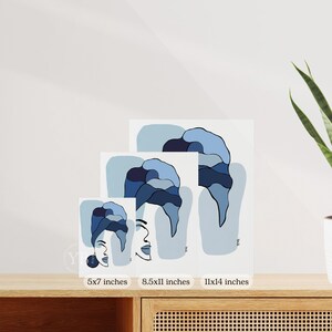 a set of three framed artworks depicting abstract blue and white designs, placed on a wooden surface.