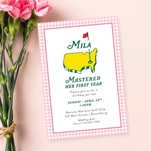 Könnte beinhalten: Eine Geburtstagseinladung mit einem rosa Vichy-Karo-Rand und einem weißen Innenraum. Die Einladung enthält den Text "Mila Mastered Her First Year" mit einer Golfplatzgrafik. Rosa Nelken sind im Hintergrund.