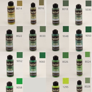 May include: A collection of 14 small bottles of green acrylic paint. The bottles are labeled with the brand name "Cadence" and a number. The paint is for use in art and craft projects.