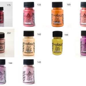 Può includere: Dieci bottiglie di vernice metallizzata in vari colori, tra cui oro, argento, rosa e rame. Ogni bottiglia è etichettata "Cadence" e "Deep Metal Paint Tint".