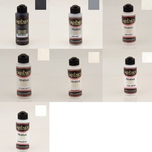 Puede incluir: Una colección de pinturas acrílicas en botellas blancas con tapas negras. Las etiquetas muestran la marca "CADENCE" y el color de la pintura. Los colores incluyen negro, gris y varios tonos de blanco. Cada botella mide unos 10 cm de altura.