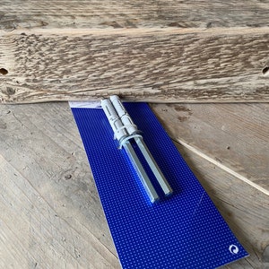 May include: Two silver metal drywall anchors packaged on a blue background with white polka dots. The anchors are used for hanging heavy objects on drywall.