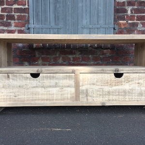 May include: A rustic wooden TV stand with two drawers and an open shelf. The stand is made of reclaimed wood and has a natural, weathered finish.