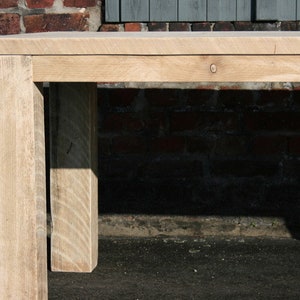 K&ouml;nnte beinhalten: Nahaufnahme eines hellen Holztisches mit nat&uuml;rlicher Oberfl&auml;che. Der Tisch hat ein schlichtes Design mit einer rechteckigen Tischplatte und vier Beinen. Der Tisch ist aus massivem Holz gefertigt und hat einen rustikalen Look.