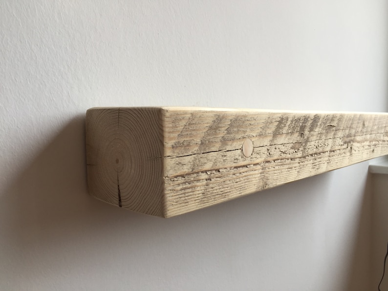 May include: A rustic wooden shelf with a natural finish. The shelf is made from reclaimed wood and has a knot hole on the top surface.