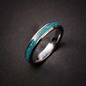 Peut inclure: Une bague en argent avec une fine bande d'opale bleue et verte.