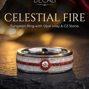 Op de afbeelding: Een wolfraam ring met een witte opaal inleg, een horizontale rode band en een centrale ronde zirkonia steen. De tekst DECAZI CELESTIAL FIRE Tungsten Ring with Opal Inlay & CZ Stone is zichtbaar boven de ring in deze productweergave.