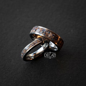 May include: Two silver rings with a brown and blue inlay. The rings are stacked on top of each other.