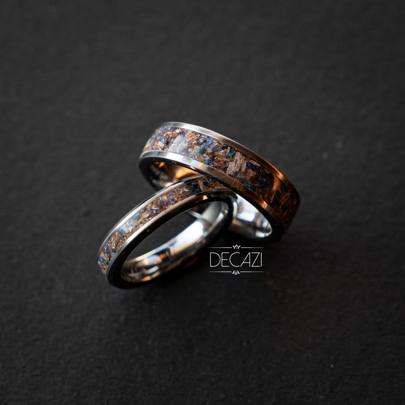 May include: Two silver rings with a brown and blue inlay. The rings are stacked on top of each other.