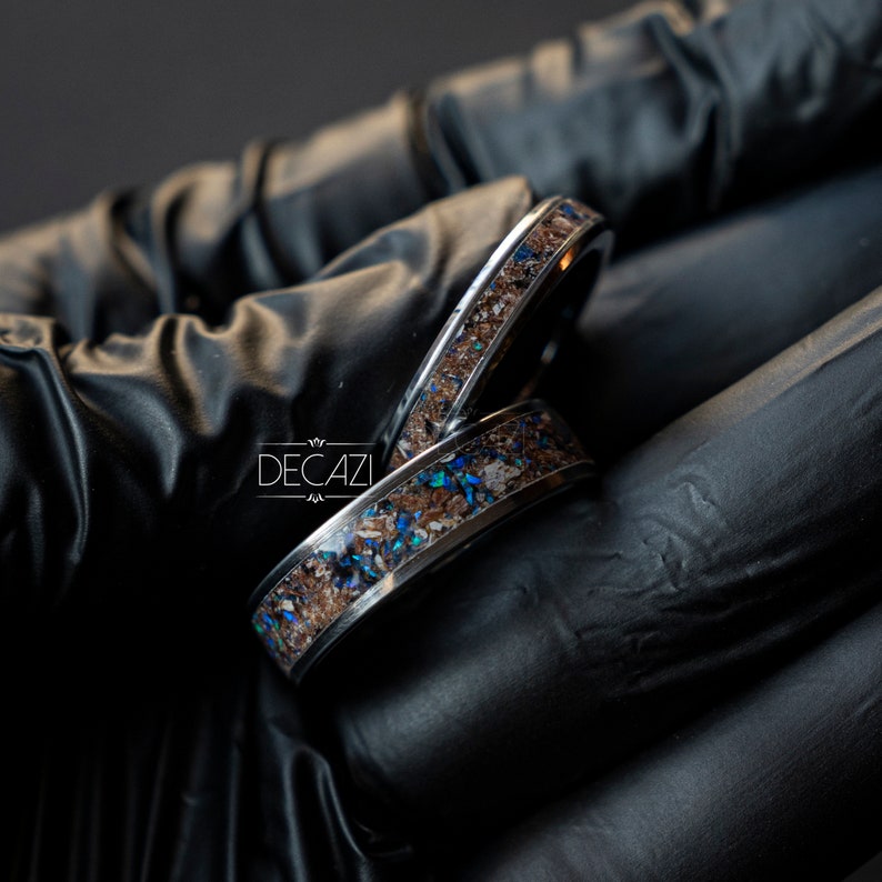 May include: Two silver rings with a brown and blue inlay. The rings are stacked on top of each other.