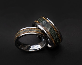 May include: Two silver rings with a green and gold inlay. The rings are stacked on top of each other.
