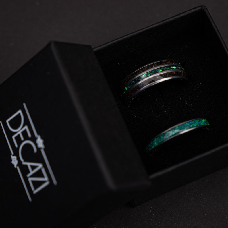 May include: Two black and green rings in a black box with the word "DECAZI" printed on the box.