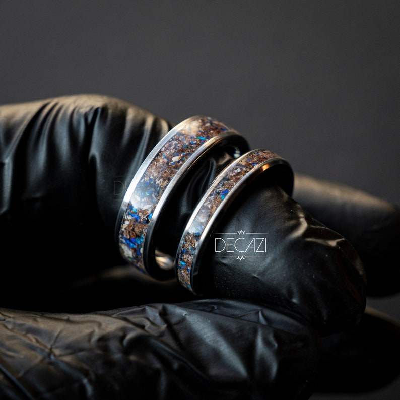 May include: Two silver rings with a brown and blue inlay. The rings are stacked on top of each other.