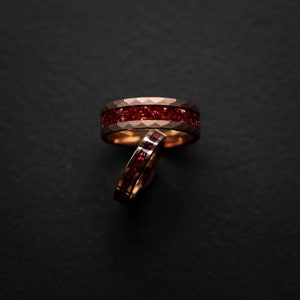 K&ouml;nnte beinhalten: Zwei goldene Ringe mit einem roten Edelstein-Inlay. Die Ringe sind &uuml;bereinander gestapelt.
