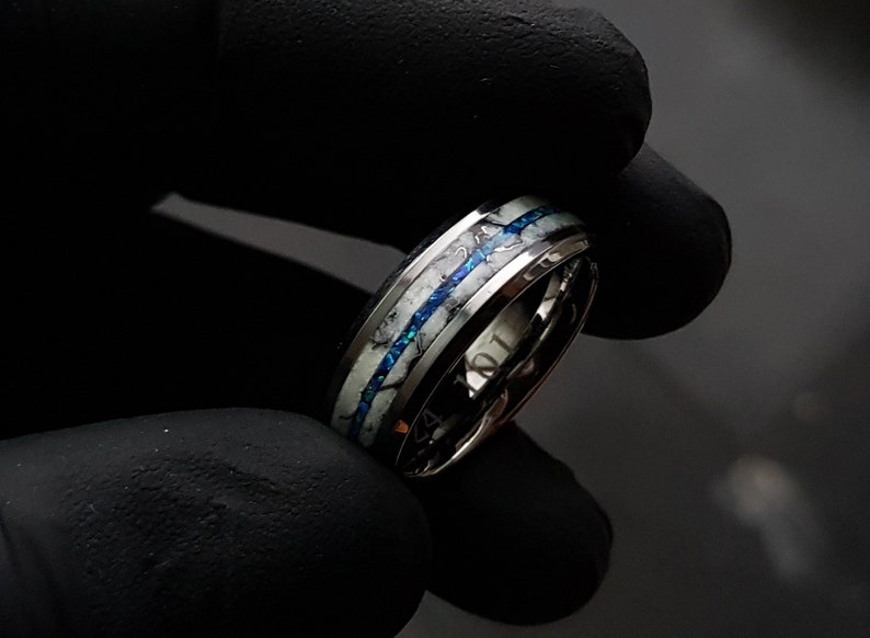 May include: A silver ring with a white and blue inlay. The inlay has a marbled pattern.