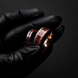 K&ouml;nnte beinhalten: Zwei Ringe aus Ros&eacute;gold mit roten Edelstein-Inlays. Die Ringe sind &uuml;bereinander gestapelt.