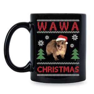 Puede incluir: Taza de cerámica negra con un diseño navideño blanco y rojo que presenta un quokka con un gorro de Papá Noel. El texto "Wawa Christmas" está impreso en la taza.