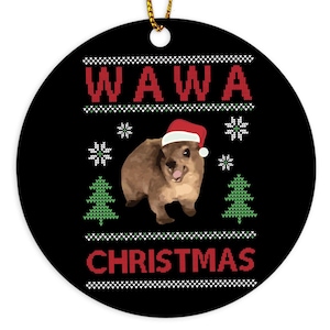 Puede incluir: Un adorno navideño negro con la palabra "WAWA" en rojo, un animal marrón con un gorro de Papá Noel y la palabra "CHRISTMAS" en rojo. El adorno tiene una cuerda dorada para colgar.