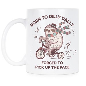 May include: White ceramic mug featuring a cartoon sloth riding a tricycle. The sloth wears a hat and scarf, with text reading "BORN TO DILLY DALLY, FORCED TO PICK UP THE PACE." The design includes stars and motion lines.
