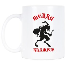 May include: White ceramic coffee mug featuring a black silhouette of Krampus, a mythical creature, carrying a sack and a bundle of twigs. The text "Merry Krampus" is printed in red on the mug.